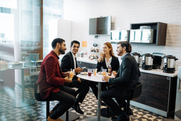 istock Latino employees taking a break at work, eating snack and chatting. 1204590259