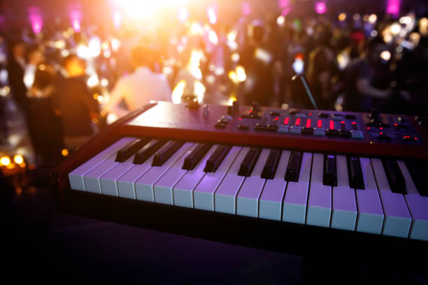 istock Piano keys in purple light on concert stage. Synthesizer. 1204594503