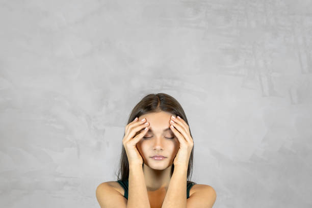 istock Young pretty woman with headache  on grey background. copy space 1204594861
