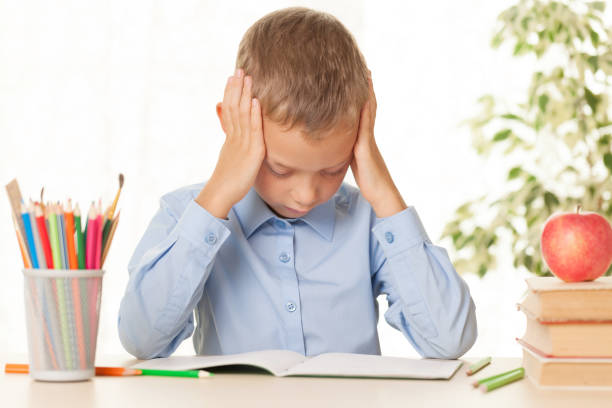 istock Young schoolboy sitting at the table and doing homework 1204596031