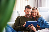 Couple using a tablet in living room
