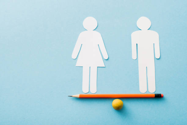 small ball and pencil with paper cut of couple isolated on blue, sexual equality concept small ball and pencil with paper cut of couple isolated on blue, sexual equality concept gender equality stock pictures, royalty-free photos & images