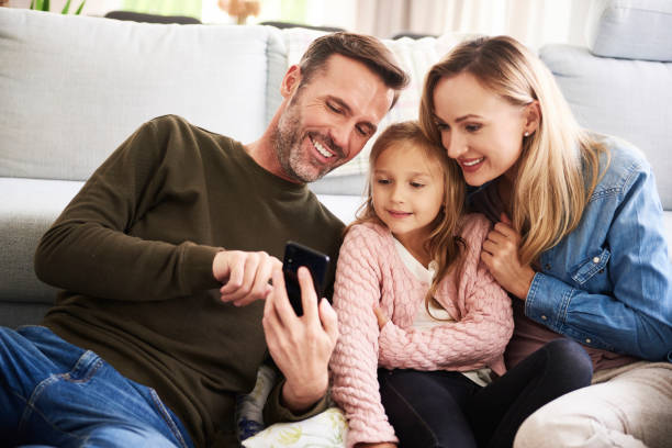istock Parents and their daughter looking at mobile phone 1204597133