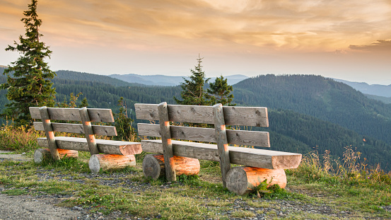Benches on the Feldberg with a view over hazy hills in the evening.
