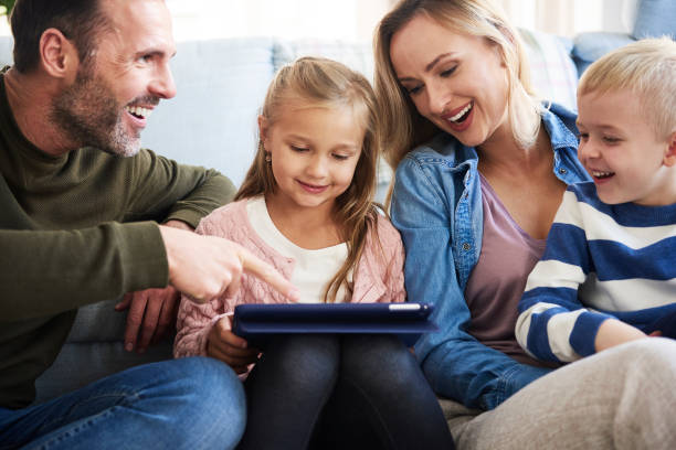 istock Cheerful family using tablet in living room 1204597987