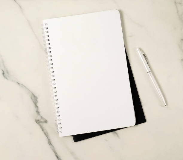 istock Notebook mock up and pen top view on marble background. Copy space 1204598087