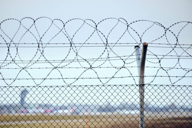 istock High chain-link fence with razor-barbed wire 1204601712