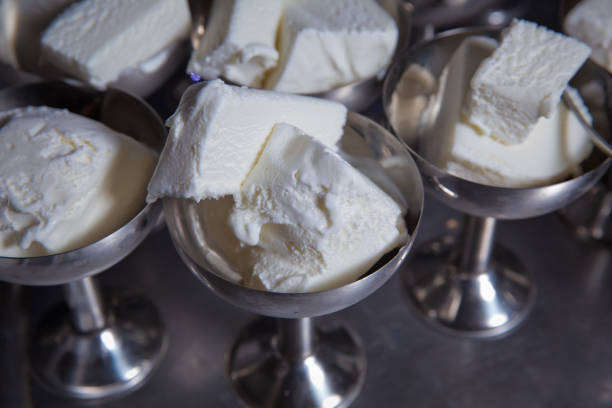 Ice cream in two retro metal bowls on a table . White ice cream in metal ware in the tray. Selective focus. Stainless ice cream cup that arrange in the