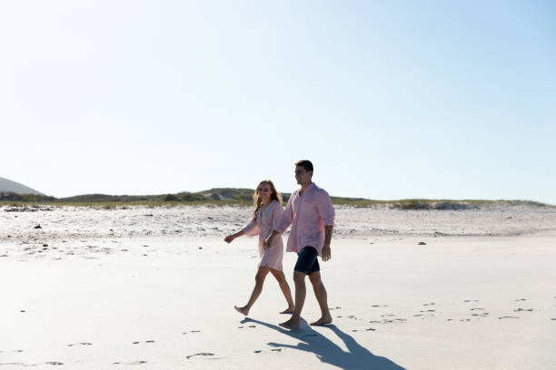 istock Side view of young couple at the beach 1204612474