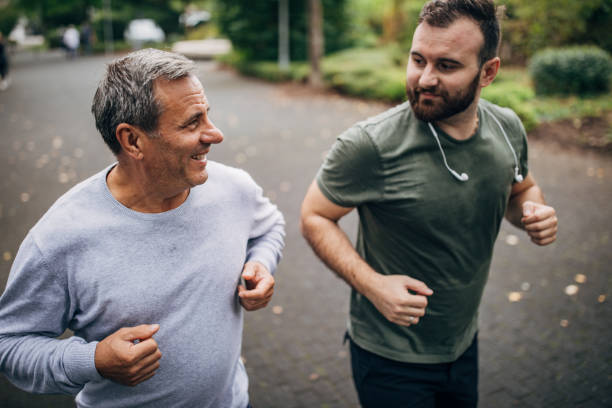 istock Son and father jogging in a public park 1204613831