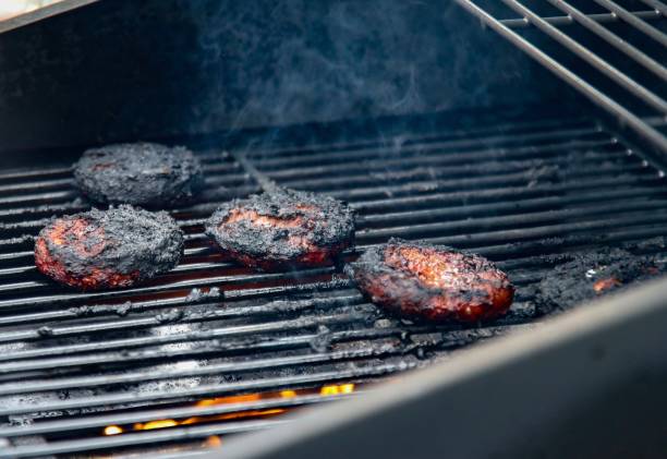 verbrannte burger - vom holzkohlengrill stock-fotos und bilder