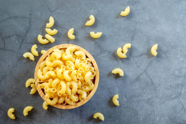istock raw elbow macaroni in wooden bowl 1204615820
