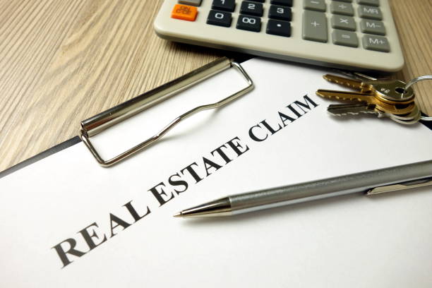 istock Real estate claim form with pen keys and calculator 1204616846