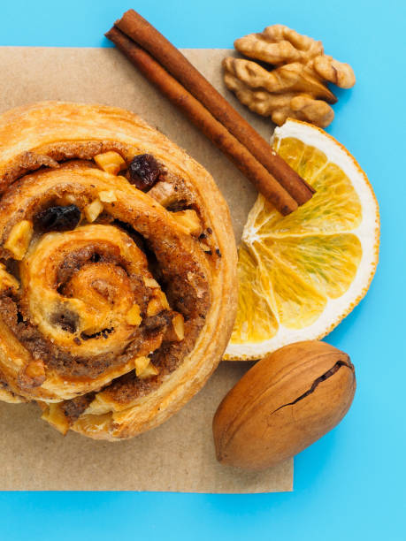 istock Cinnamon bun with nuts and lemons on a blue background 1204617334