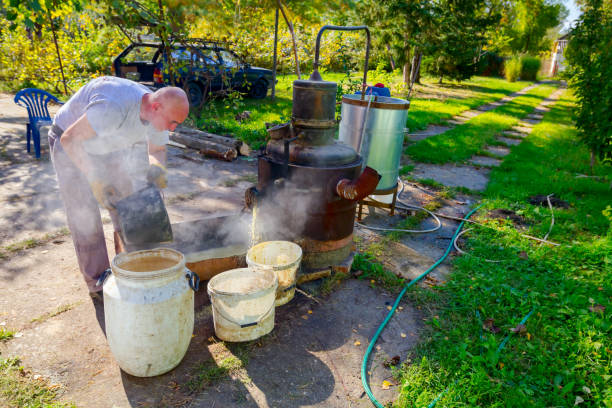istock Man is empty fruit marc from distillation apparatus after cooking and making 1204618424