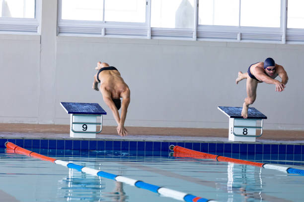 istock Swimmers plunging in the pool 1204618830