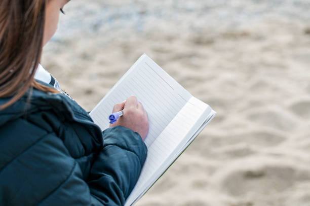 istock Little adorable girl with notebook on tropical beach 1204618931