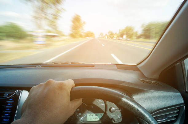 istock man driving car from rear view on the highway. 1204619133