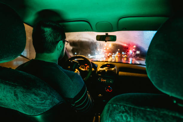 istock Man driving car on city streets 1204620433
