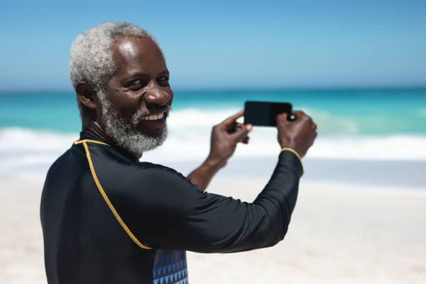 istock Old man taking pictures of the beach 1204623045
