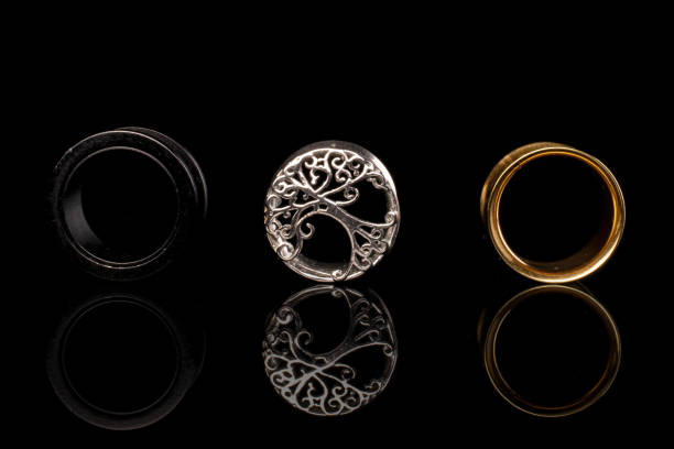 istock Stylish ear plug isolated on black glass 1204623950
