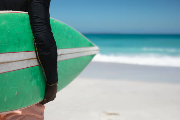 Old man with a surfboard at the beach