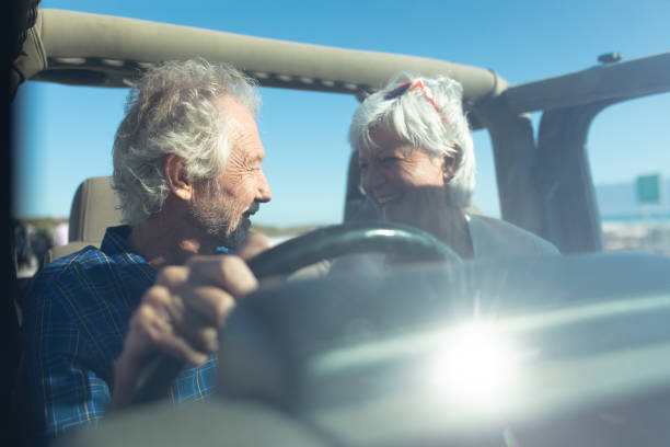 istock Old couple with a car at the beach 1204626255