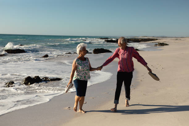 istock Old couple walking at the beach 1204627791
