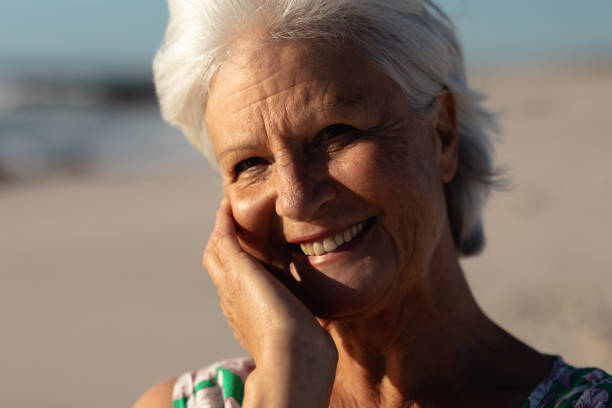 istock Old woman smiling at the beach 1204627848