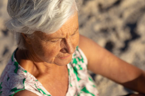 istock Old woman relaxing at the beach 1204627904