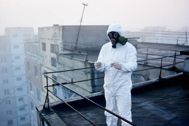 istock Worker scientist wearing protective coverall and gas mask doing ecological tests on the roof 1204628375
