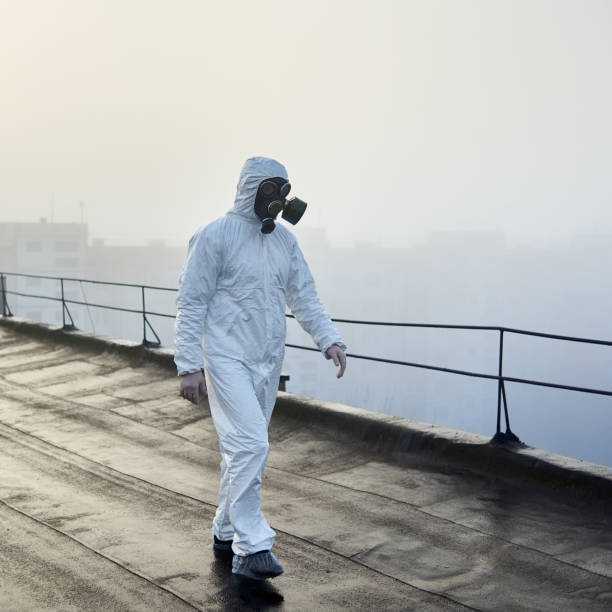 istock Worker scientist wearing protective coverall and gas mask doing ecological tests on the roof 1204628474