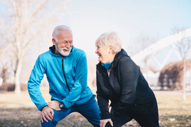 un couple âgé s’étirant et s’amusant dans le parc. - senior couple audio photos et images de collection