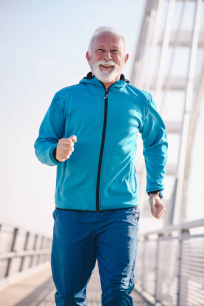 istock A senior sportsperson running on a bridge walkway, cheerful and smiling. 1204630014