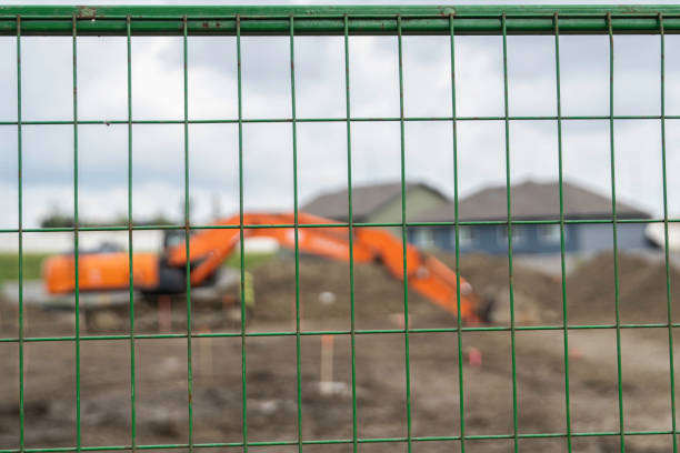 istock construction equipment behind a fence on a construction site 1204630114