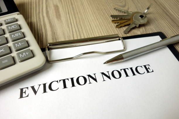 istock Home eviction notice legal document with pen calculator and keys 1204630648