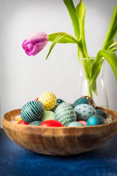 istock Easter bunny in basket with colorful eggs and tulips on wooden table. Easter holiday decorations , Easter concept background. 1204631449