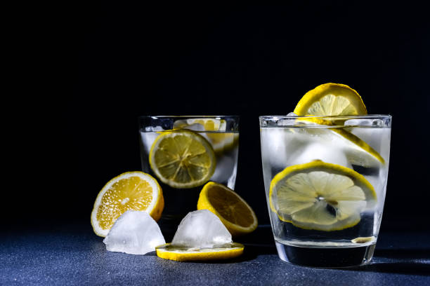 istock splash Gin and tonic cocktail with lemon slices Ice cube falls into water with lemon Copy space, lemonade 1204632199