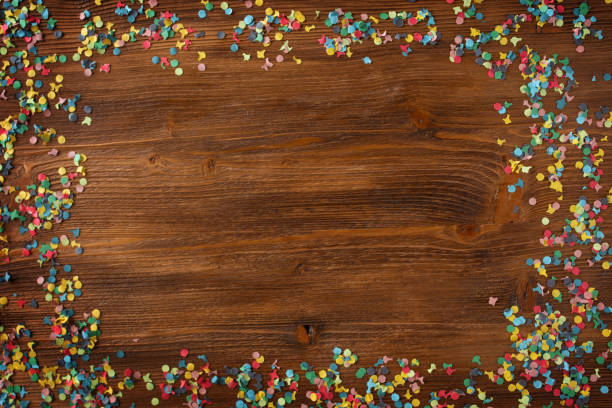 istock Colorful confetti on wooden texture 1204632949