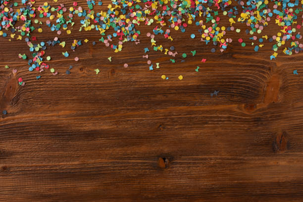 Colorful confetti on wooden texture