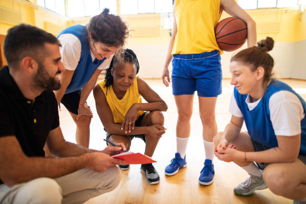 istock Multi-ethnic Female basketball team talking with coach about game strategy 1204634332