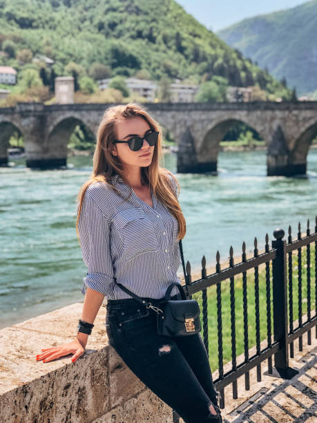 istock Woman sitting by the bridge on Drina river 1204638490