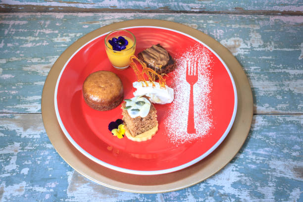 Chocolate brownie, malva pudding, pumpkin spice cake with glazed frosting and lemon curd in a small glass on a red plate with icing sugar decoration Chocolate brownie, malva pudding, pumpkin spice cake with glazed frosting and lemon curd in a small glass on a red plate with icing sugar decoration tea party horizontal nobody indoors stock pictures, royalty-free photos & images