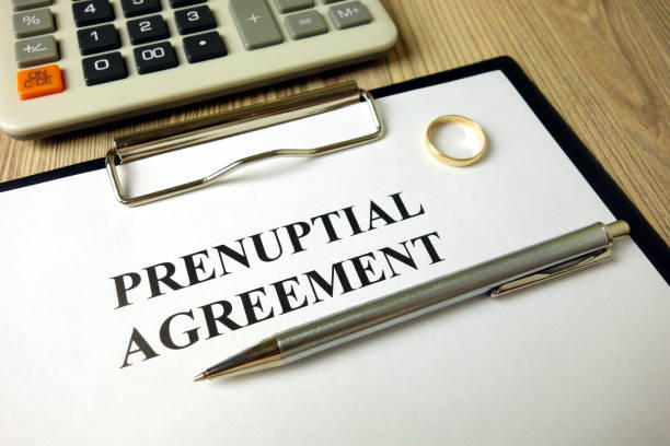 istock Prenuptial agreement with pen calculator and wedding ring 1204639859