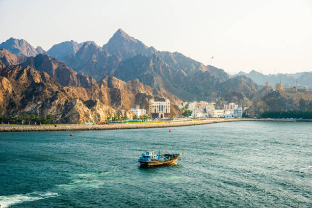 vista sulle montagne al tramonto - skyline della baia del porto di muscat, capitale dell'oman - oman greater masqat fort tourism foto e immagini stock