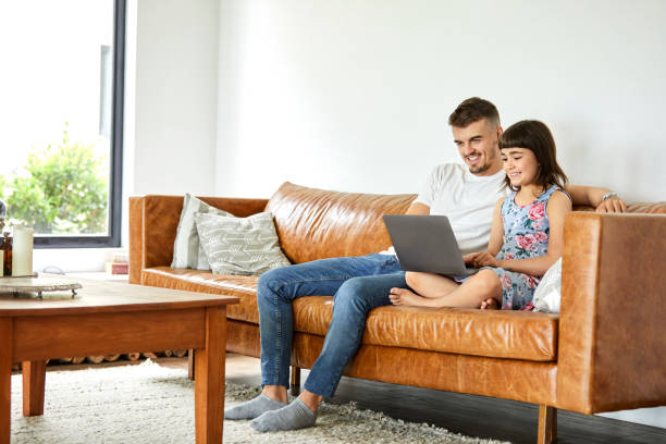 istock Smiling father and daughter using laptop at home 1204641113