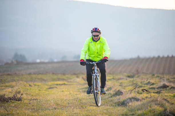 Silhouette of a boy riding a mountain bike on the hill at yellow red and blue sunset sky color.