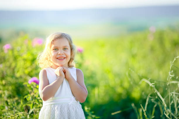istock Girl on the meadow with flowers 1204643992