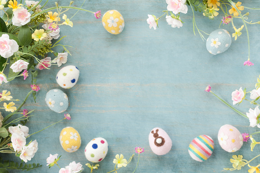 Easter Eggs and Flowers on a Rustic Textured Blue Wood Background