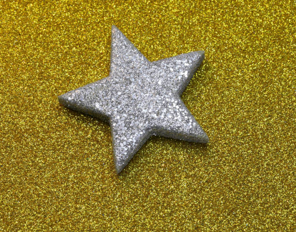 istock big silvered Star on Golden Glitter Background 1204646377